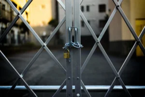 Image shows a gate locked with a chain and a large