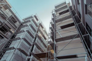 Image features tall building scaffolding shot from the level of the street