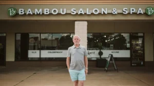 Image shows man standing in front of Bambou Salon & Spa.